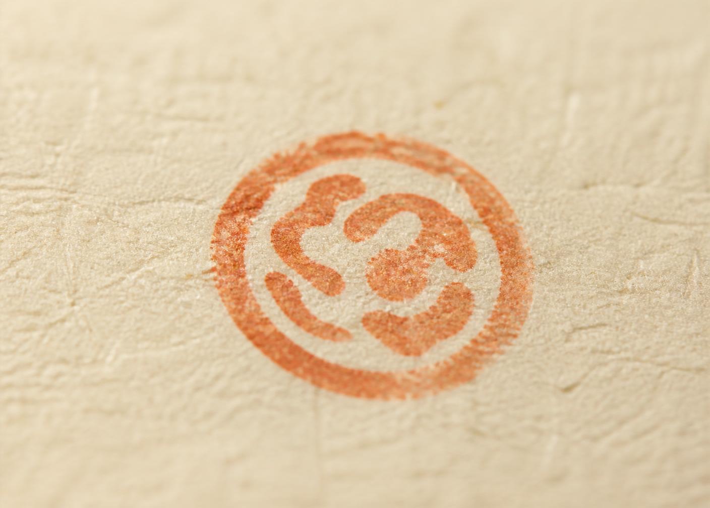 A single terracotta ink stamp on warm paper — the mark of an operator's approval.